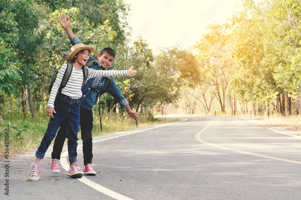 Fototapeta premium Happy Asian children backpack in the road and forest background