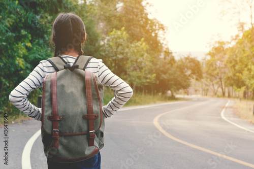 Happy Asian girl backpack in the road and forest background