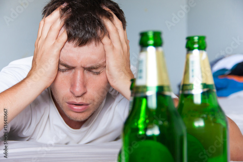 Fotografie Young caucasian man has hangover after drink party