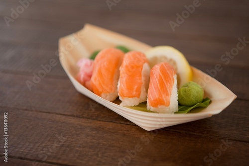 Three nigiri sushi served in wooden boat plate
