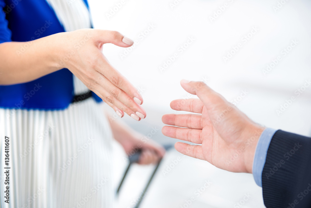 Businesswoman making handshake with a businessman at the airport