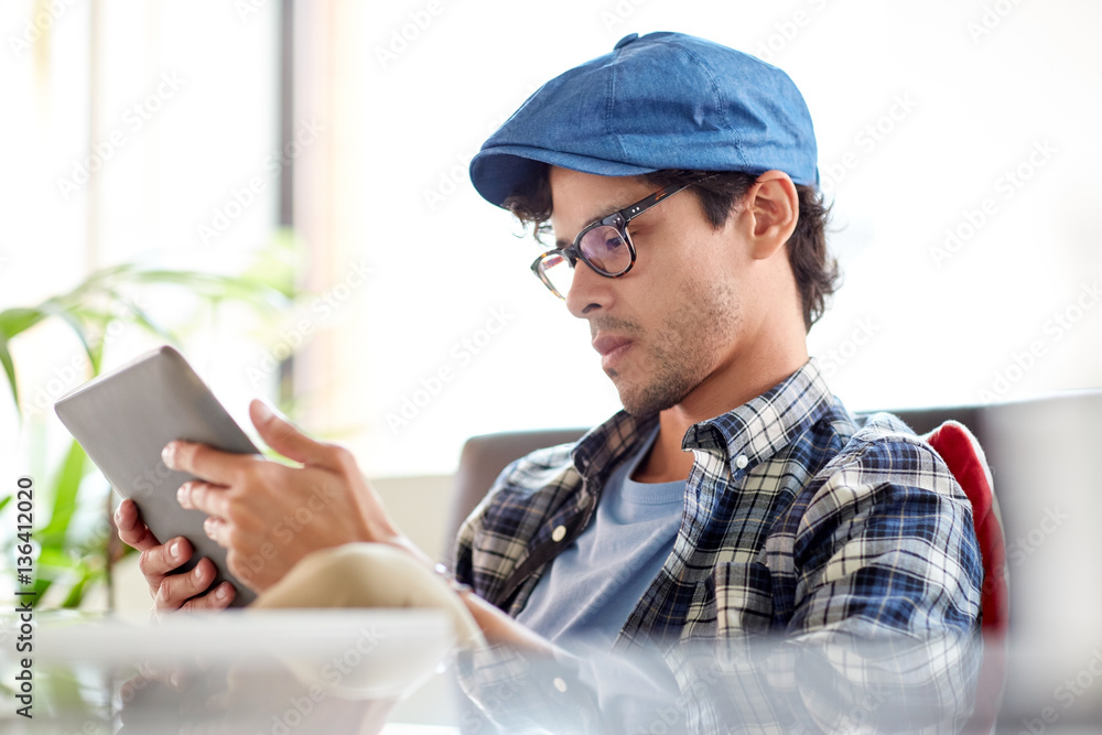 man with tablet pc sitting at cafe table