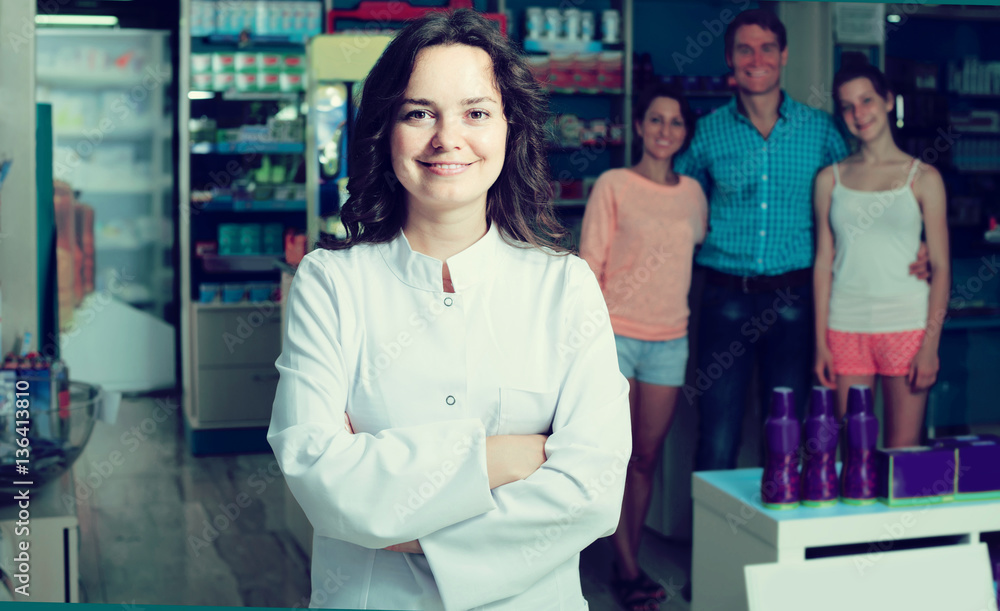 portrait of  female druggist in white coat working in pharmacy