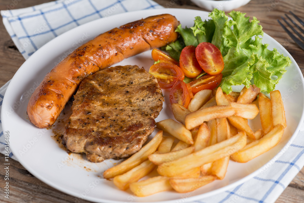 Close up, Roasted beef meat steak and sausage with french fries. Close up, Roasted beef meat steak and sausage with french fries.