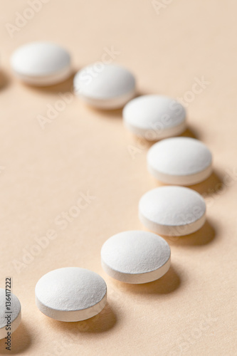 white pills on beige background