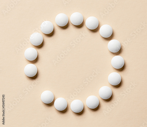 Plakat white pills on beige background