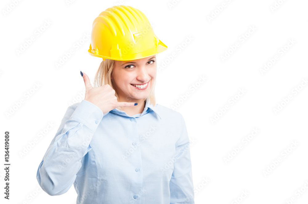 Female architect wearing helmet showing call me gesture