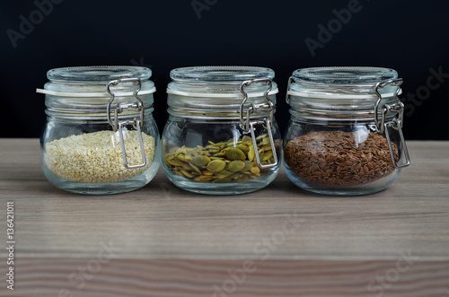 Collection of sesame seeds, flax seeds, pumpkin seeds in glass jar