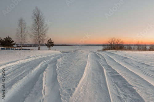 snowy road in winter village at dawn.