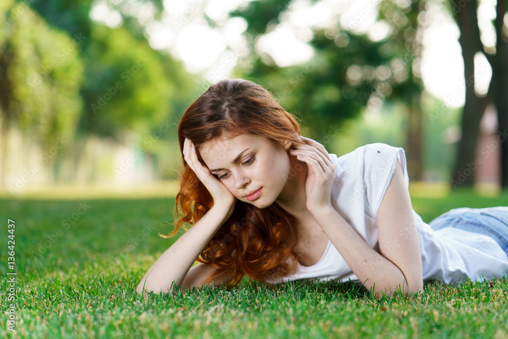 beautiful woman lies on the grass and the trees in the background beautiful woman lies on the grass and the trees in the background