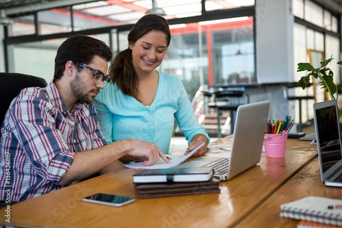 Business executives discussing charts and graphs on desk