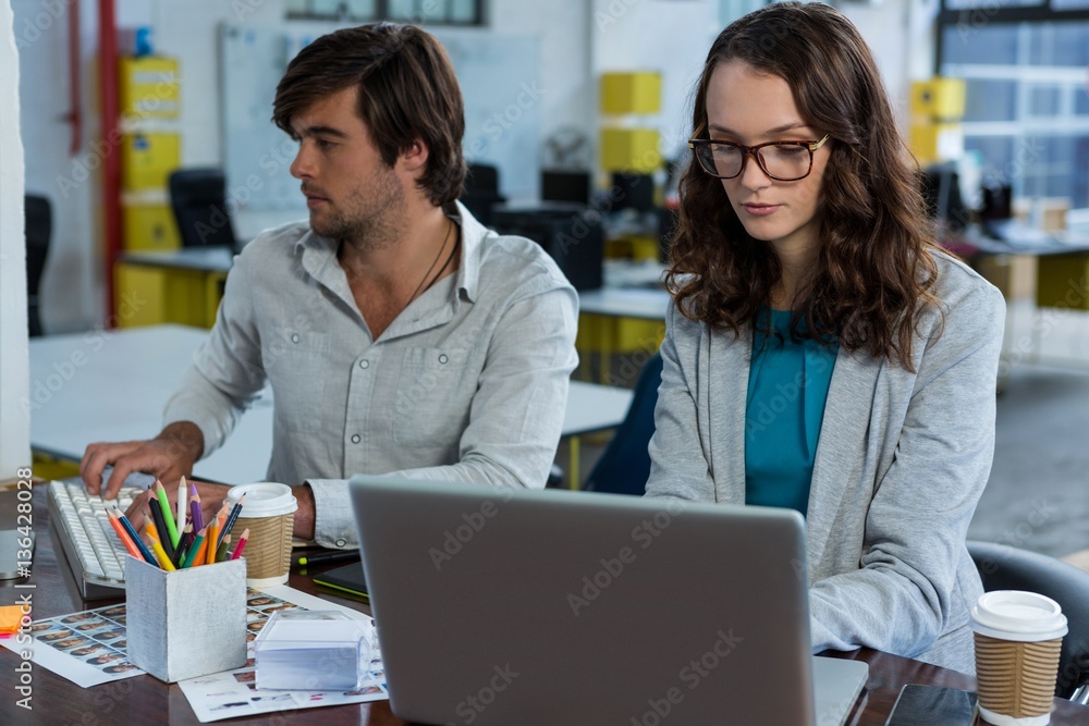 Graphic designers working at desk Graphic designers working at desk