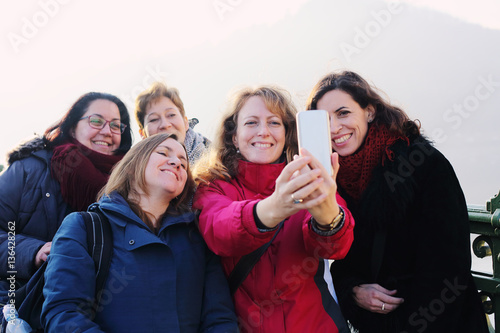 Outdoor portrait of five friends taking selfie with a smartphone