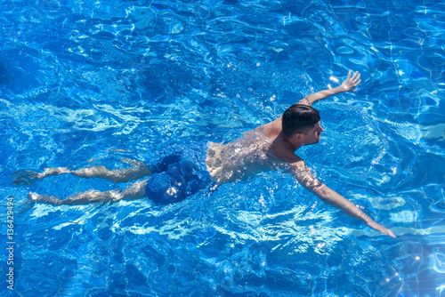 Attractive man swimming in the pool