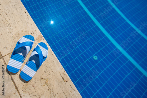 Edge of the pool with striped sandals