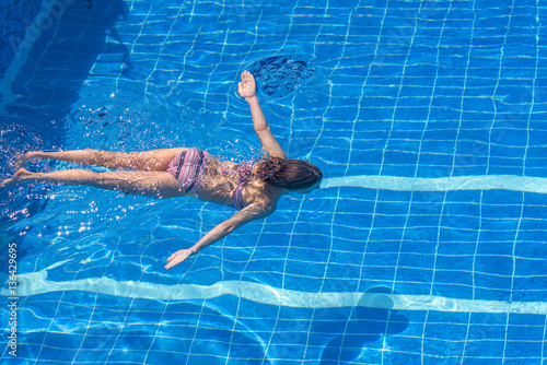 Woman in a bikini swimming in the pool