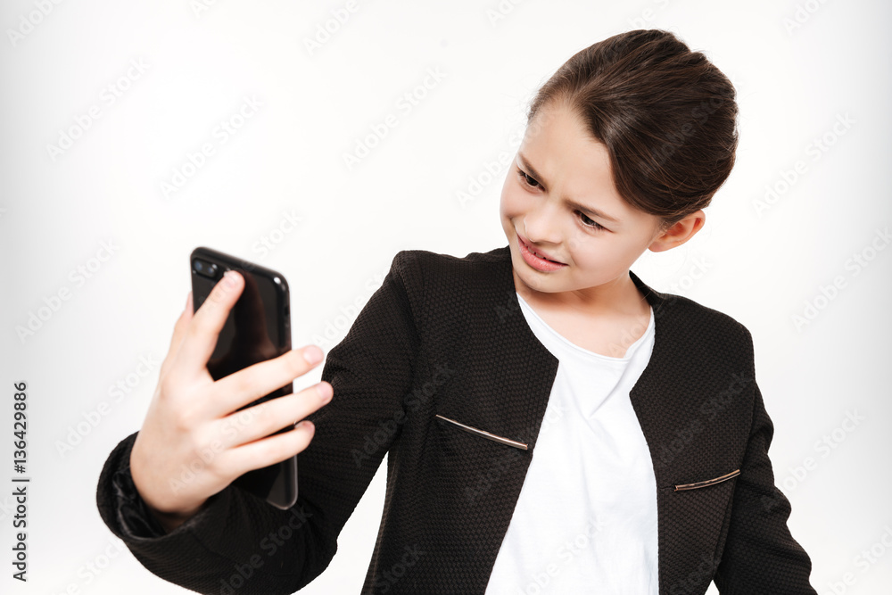 Attractive young girl standing and holding phone Attractive young girl standing and holding phone