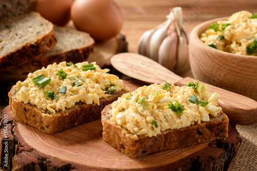Quadro em tela Whole wheat sandwiches with egg and cheese spread on wooden stump