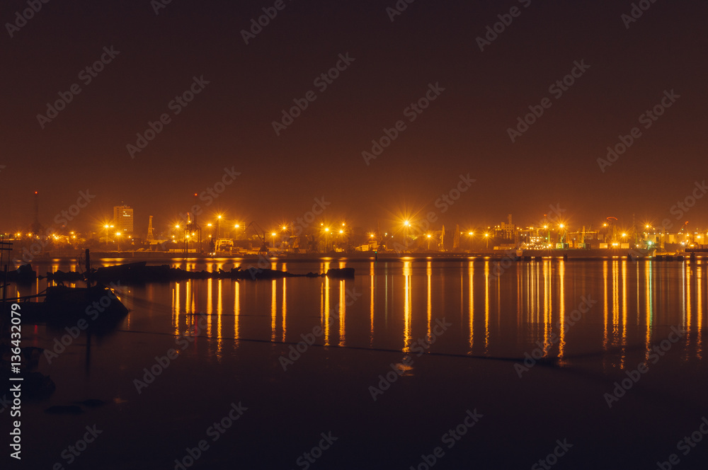 Freight harbor at night with lights reflection
