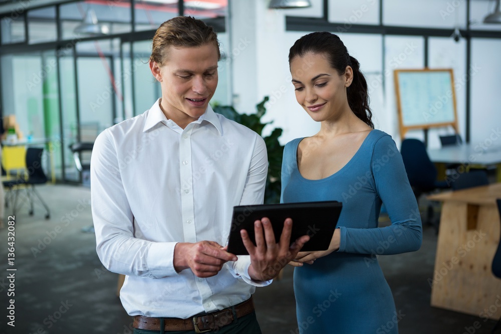 Business executives discussing over digital tablet Business executives discussing over digital tablet