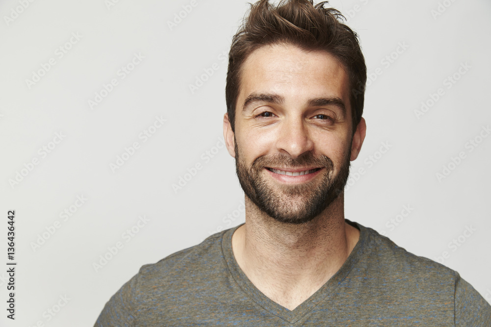 Fototapeta premium Smiling handsome dude in grey, portrait
