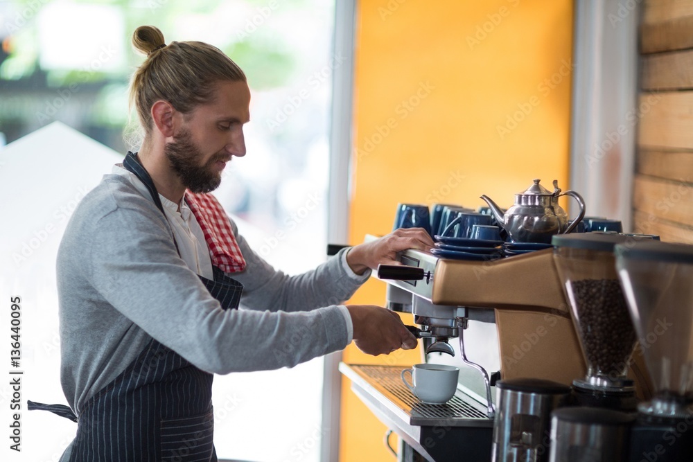 Attentive waiter making cup of coffee