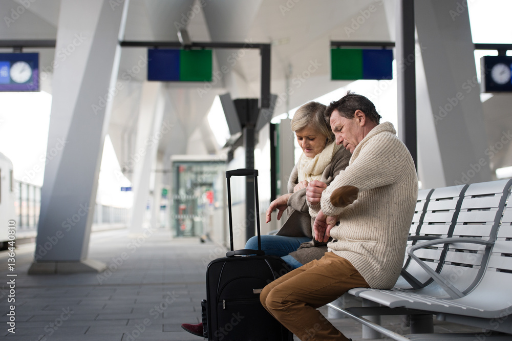 Senior couple waiting on train station, looking at watch. Senior couple waiting on train station, looking at watch.