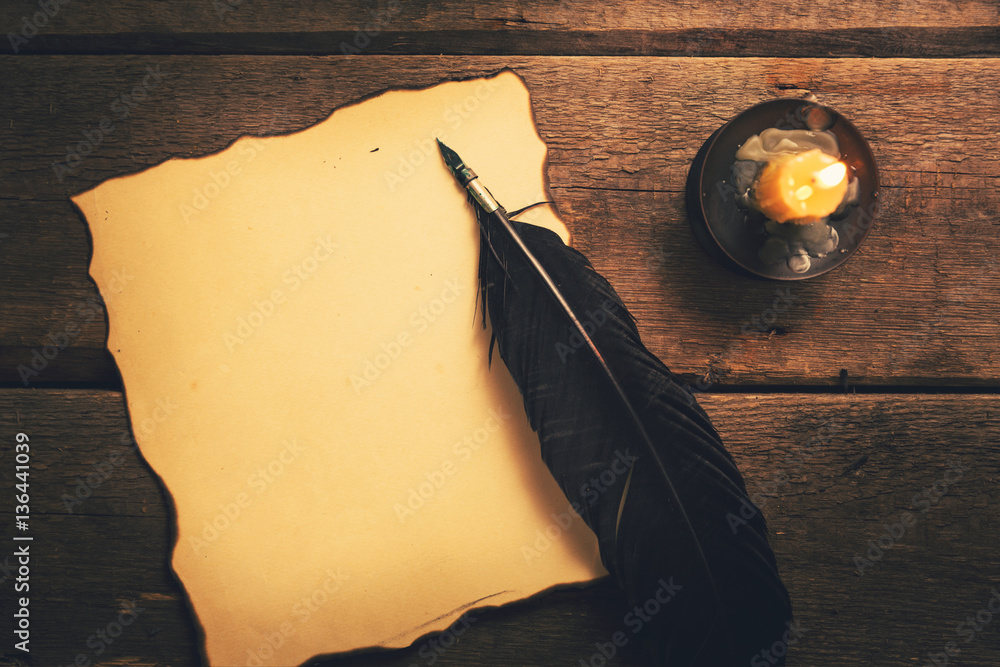 Foto de vintage feather pen and blank old paper in candlelight on the table  do Stock | Adobe Stock