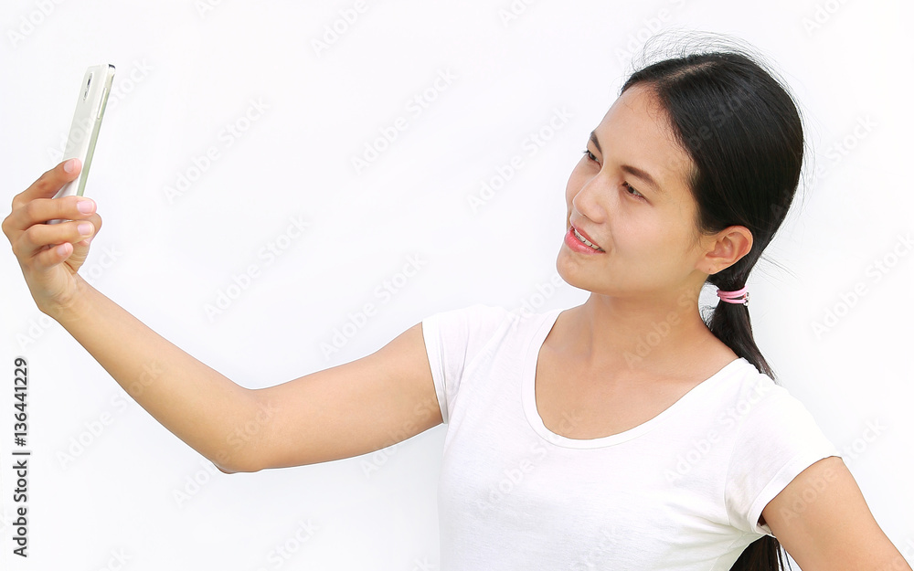 Close up asian girl taking pictures of herself through cell phone on white background Close up asian girl taking pictures of herself through cell phone on white background