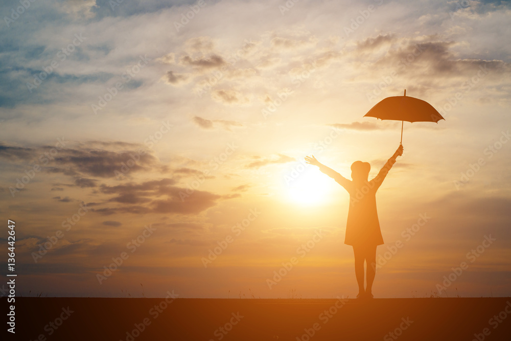 Silhouette of Woman with Umbrella on sunset background.