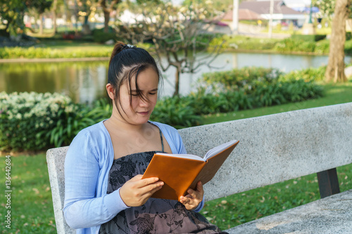 beautiful girl reading a book in the park