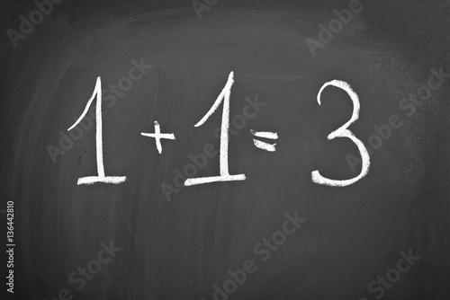 example of 1 + 1 = 3 on a blackboard with chalk