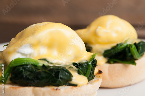 Fotografie Eggs benedict or eggs florentine on a white plate in the cafe