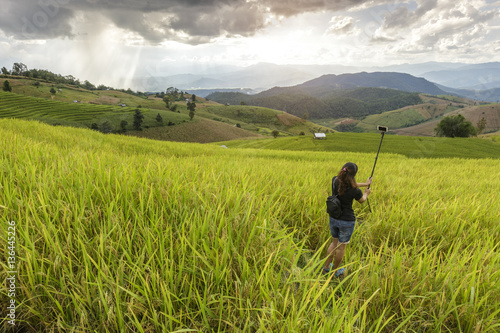 girl do selfie herself in the rice field
