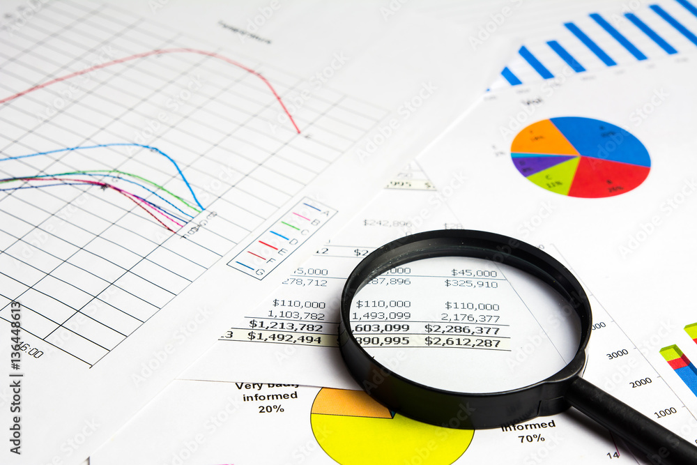 magnifying glass on financial report documents magnifying glass on financial report documents