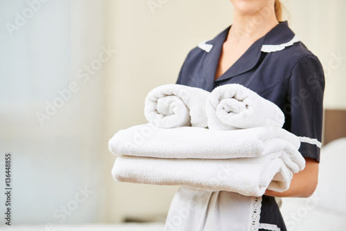 Maid with fresh towels during housekeeping photo