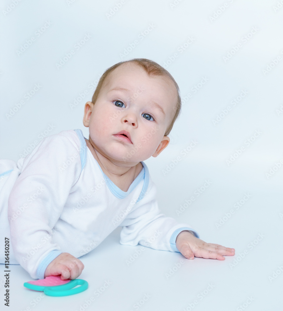 baby child lying on belly weared with teether in mouth. baby child lying on belly weared with teether in mouth.
