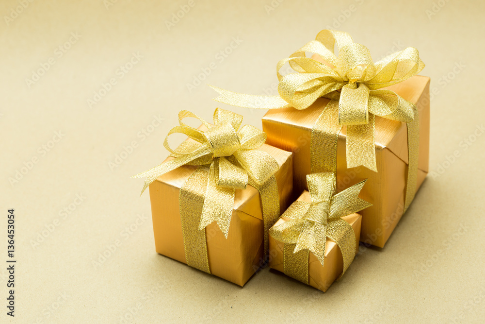 Obraz premium Gold gift box on brown paper background