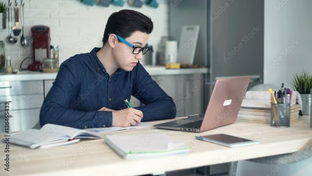 Young tired, overworked teenager doing homework with laptop computer at home
Young tired, overworked teenager doing homework with laptop computer at home