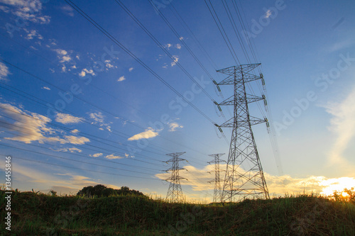 A high voltage of transmission tower in the morning sunrise with the beauty of a blue sky