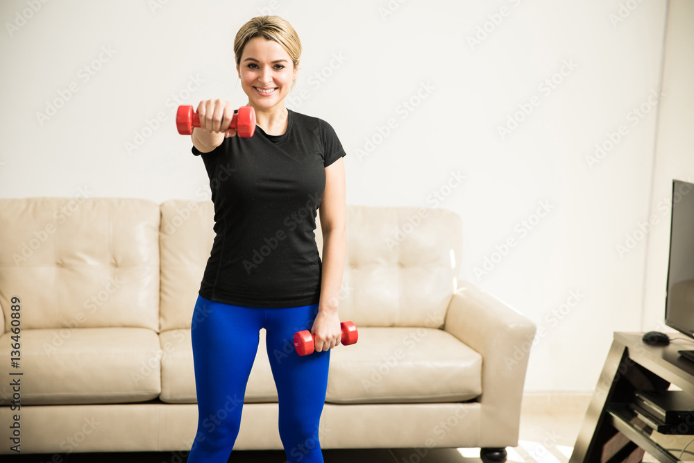 Obraz premium Beautiful woman exercising at home