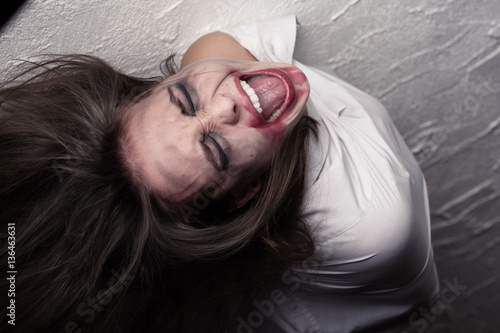 screaming crazy woman with flying hair in straitjacket photo