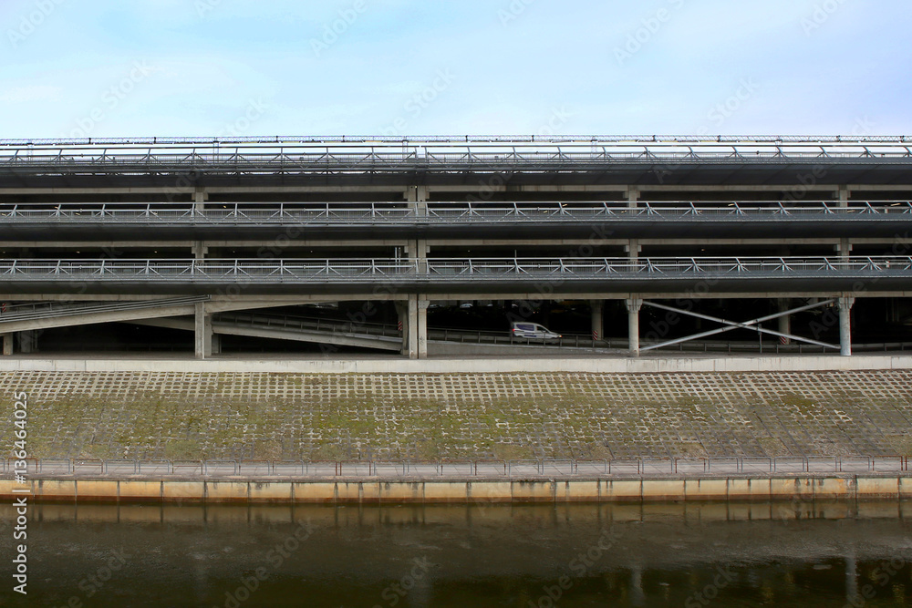 Multi Storey Parking Lot. Industrial building car parking garage near river. Multi Storey Parking Lot. Industrial building car parking garage near river.