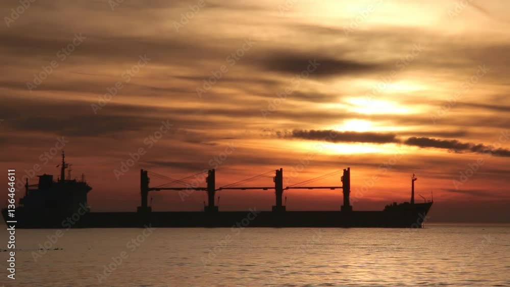 Silhouette of a ship at sunrise, Beautiful clouds over a sea, colors of sunrise Silhouette of a ship at sunrise, Beautiful clouds over a sea, colors of sunrise