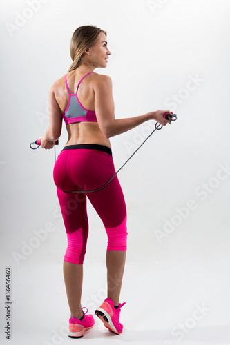 Woman in sportswear holding a rope in his hands. White backgroun