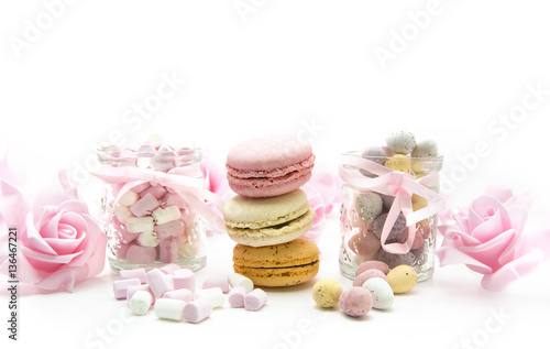Easter Treats with eggs, marhmallows, macaroons and pink roses on a white background