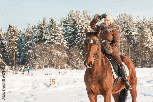 Woman in brown dress and brown horse in a winter © keleny