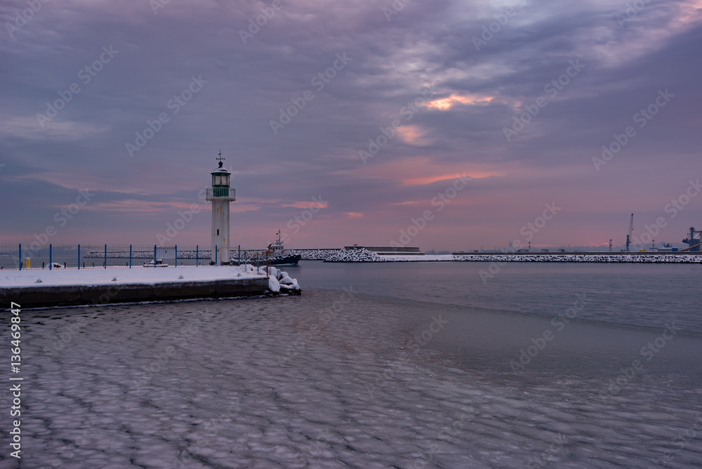 Fototapeta premium Winter fire sunset and frozen sea at the Marine station, Burgas, Bulgaria