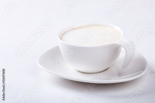 White Coffee Cup with Milk on a light Background.Copy space. selective focus.