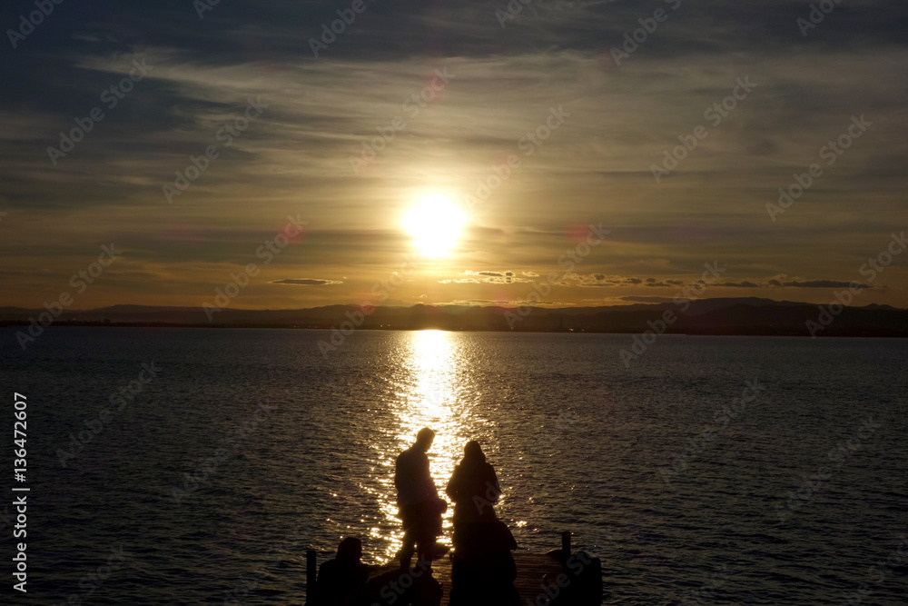 couple at a sunset in the Albufera lake, in Valencia couple at a sunset in the Albufera lake, in Valencia